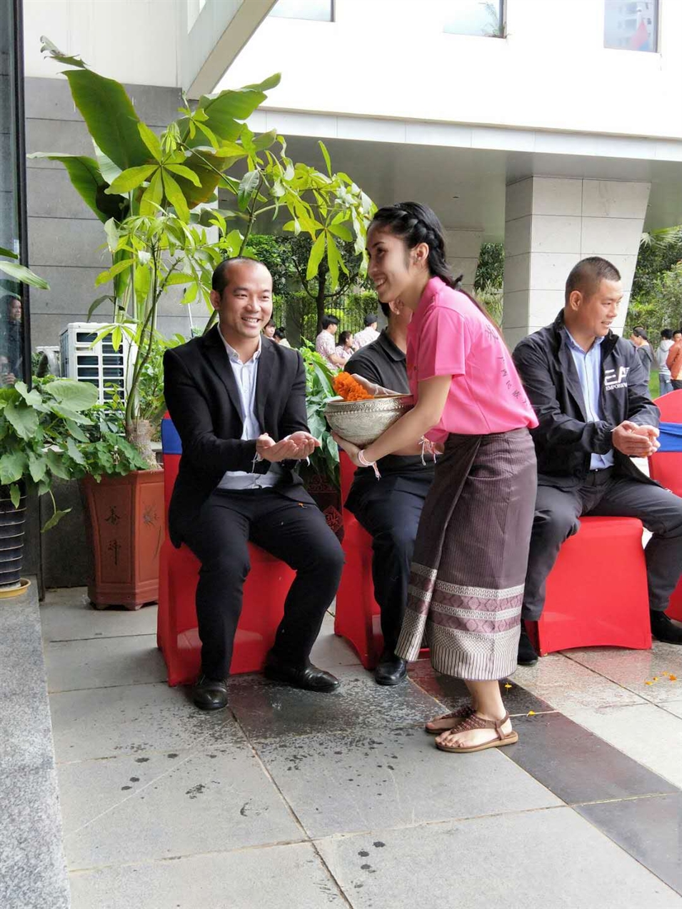 老撾駐廣西留學(xué)生代表將浸有花瓣的香水灑客人的手上，表示對嘉賓的美好祝福（圖一）