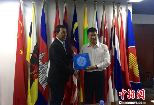 中國(guó)—東盟博覽會(huì)秘書(shū)處副秘書(shū)長(zhǎng)黃平西（右）與柬埔寨新聞部新聞與傳播總司副總司長(zhǎng)春占皮侖（左）互贈(zèng)禮物。